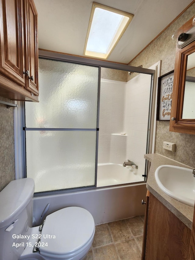 bathroom with combined bath / shower with glass door, vanity, and toilet