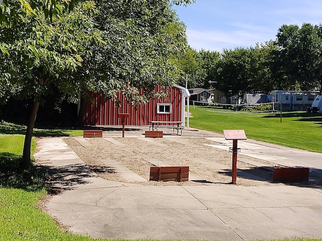 view of property's community with a lawn and an outdoor structure