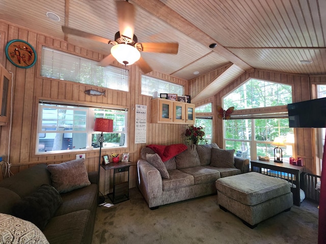 carpeted living room with high vaulted ceiling, wooden ceiling, a ceiling fan, and wooden walls