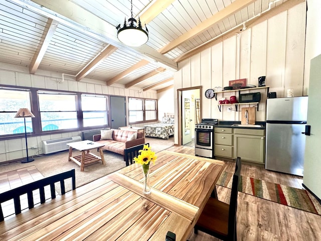 interior space with decorative light fixtures, vaulted ceiling with beams, stainless steel appliances, green cabinets, and a sink