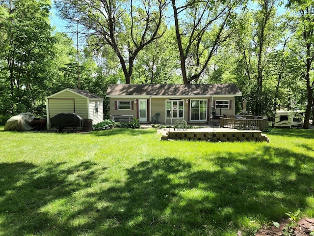 view of front facade featuring a storage shed, a front lawn, and an outbuilding