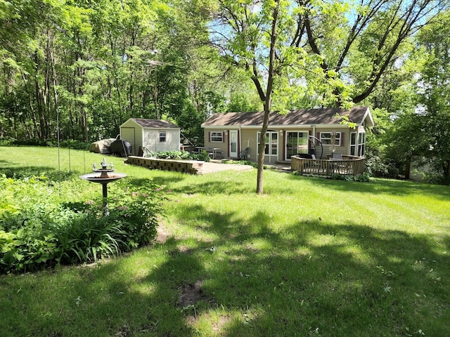 view of yard featuring an outbuilding, a wooden deck, and a shed