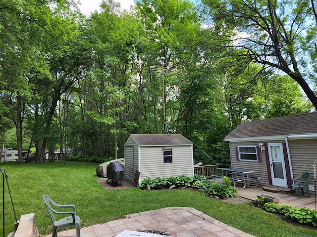 view of yard featuring an outbuilding, a deck, and a shed