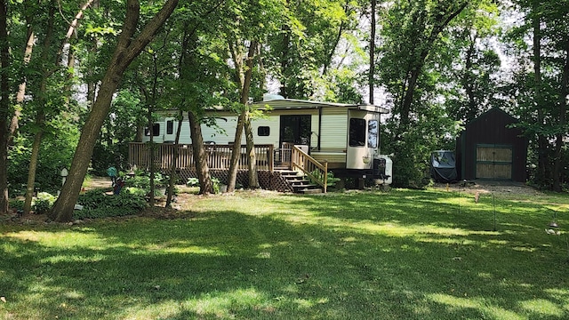 view of front of house featuring an outbuilding, a front lawn, and a wooden deck