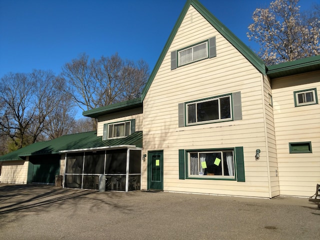 rear view of property featuring a sunroom