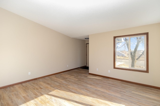 unfurnished room with light wood finished floors and baseboards