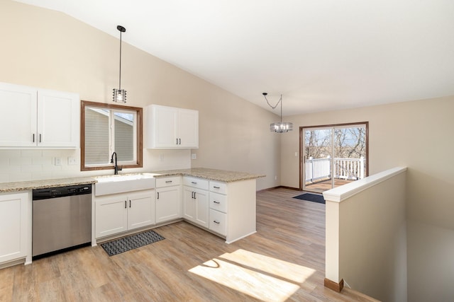 kitchen featuring stainless steel dishwasher, a sink, decorative light fixtures, and white cabinets