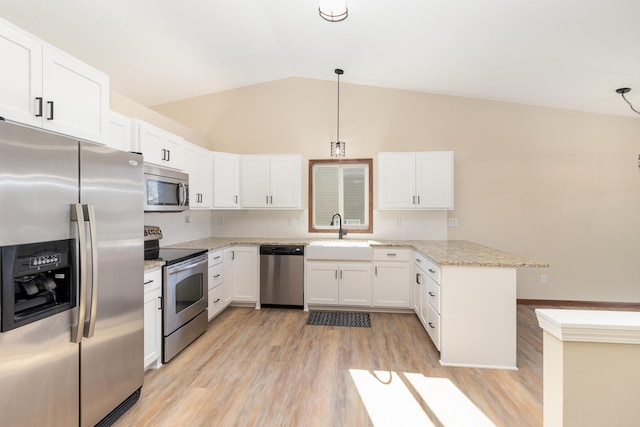 kitchen featuring appliances with stainless steel finishes, hanging light fixtures, light stone countertops, white cabinetry, and a sink