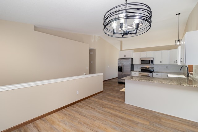 kitchen featuring appliances with stainless steel finishes, white cabinetry, a sink, and light wood finished floors