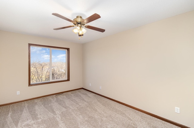 empty room featuring light carpet, ceiling fan, and baseboards