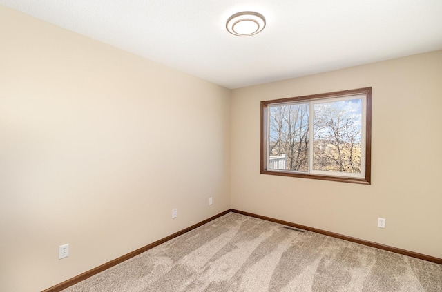 carpeted spare room featuring visible vents and baseboards