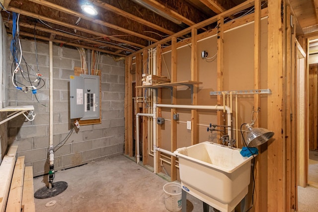 unfinished below grade area with a sink, electric panel, and concrete block wall