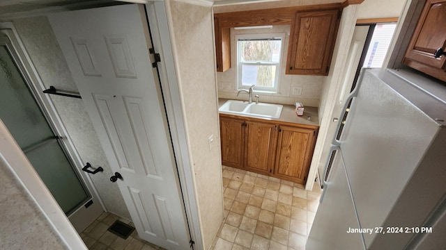 2945 County Road 4 SW Unit 118, Cokato, MN 55321 - kitchen featuring a sink, light countertops, freestanding refrigerator, and brown cabinetry
