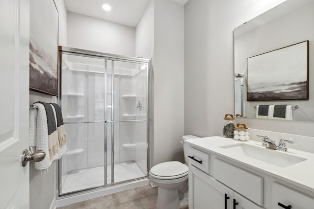 bathroom with vanity, toilet, and a stall shower