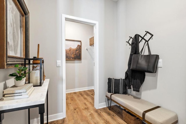 hall with baseboards and light wood finished floors