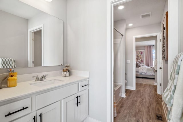 full bath with visible vents, wood finished floors, a shower with shower curtain, baseboards, and vanity