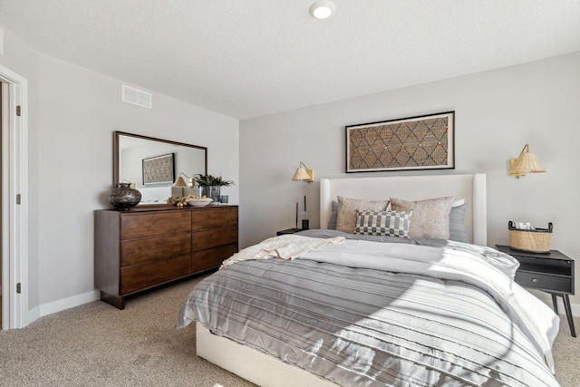 bedroom featuring carpet flooring, baseboards, visible vents, and a textured ceiling