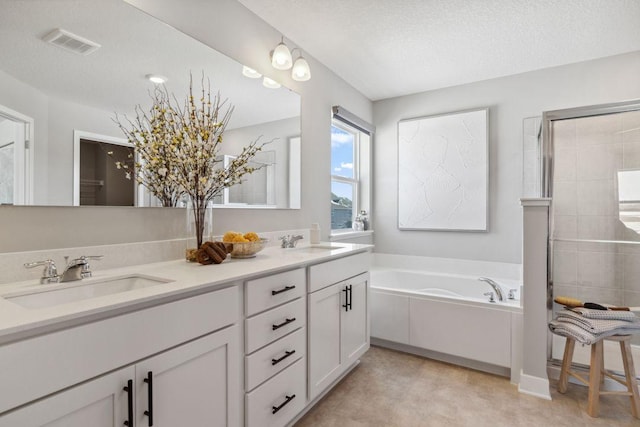 bathroom with a sink, visible vents, a bath, and double vanity