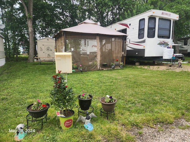 view of yard featuring a storage shed, a gazebo, and an outbuilding