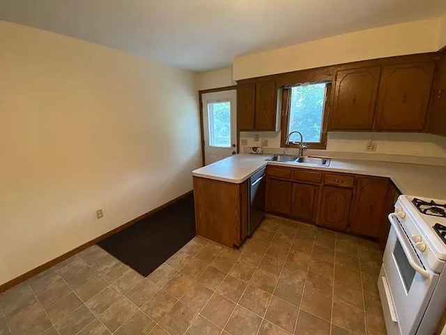 kitchen featuring a peninsula, white range with gas stovetop, a sink, light countertops, and dishwasher