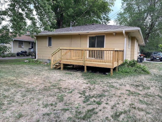 rear view of property featuring a deck and a shingled roof