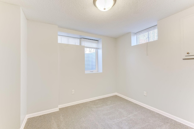 below grade area with carpet, a wealth of natural light, and baseboards