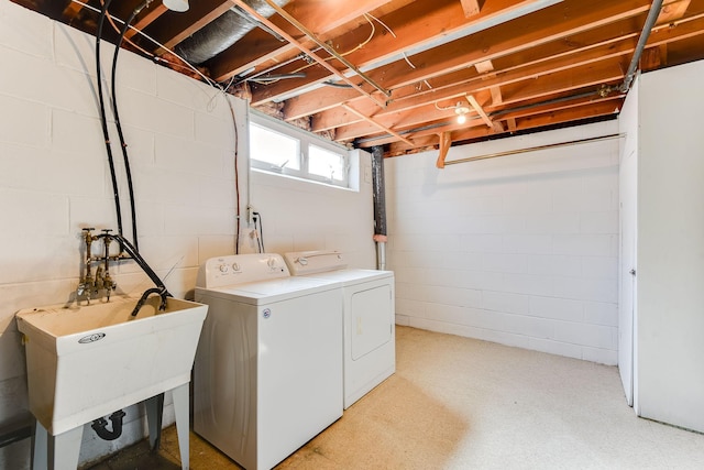 clothes washing area featuring a sink, laundry area, and washer and dryer