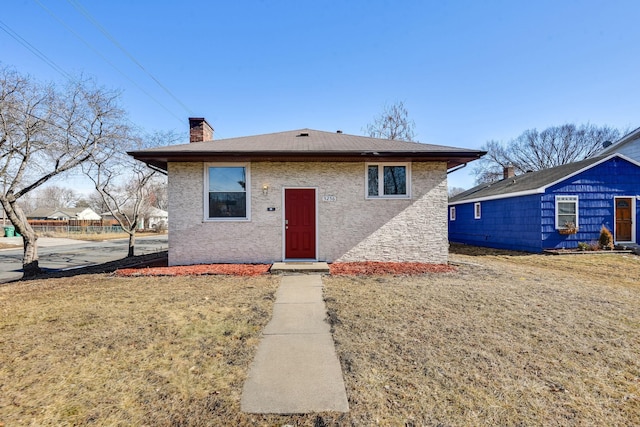 view of front of home featuring a chimney and a front yard