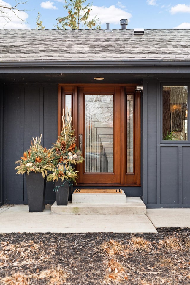 doorway to property with a shingled roof