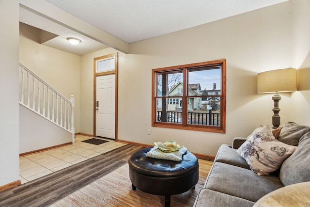 living room featuring stairs, baseboards, and wood finished floors