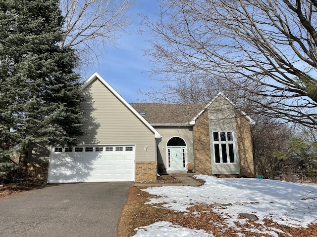 view of front of house with brick siding, driveway, and a garage