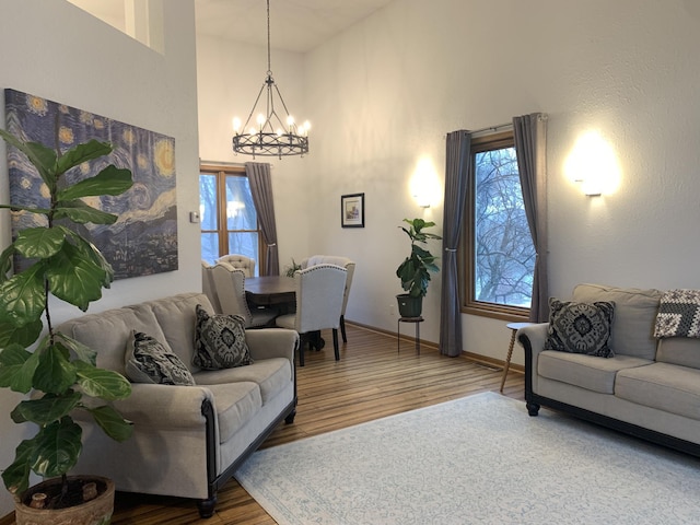 living area featuring a wealth of natural light, a notable chandelier, and wood finished floors