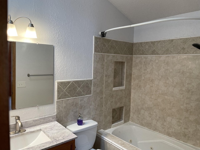 full bathroom featuring a combined bath / shower with jetted tub, toilet, vanity, a textured wall, and tile walls