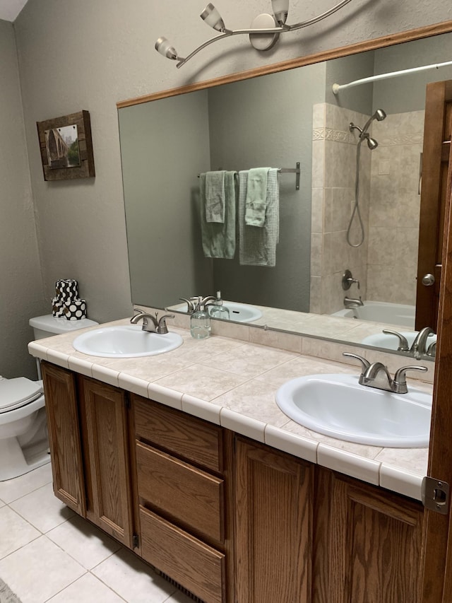 bathroom with double vanity, toilet, and a sink