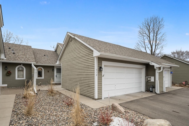 view of front of home featuring a shingled roof, a garage, and aphalt driveway