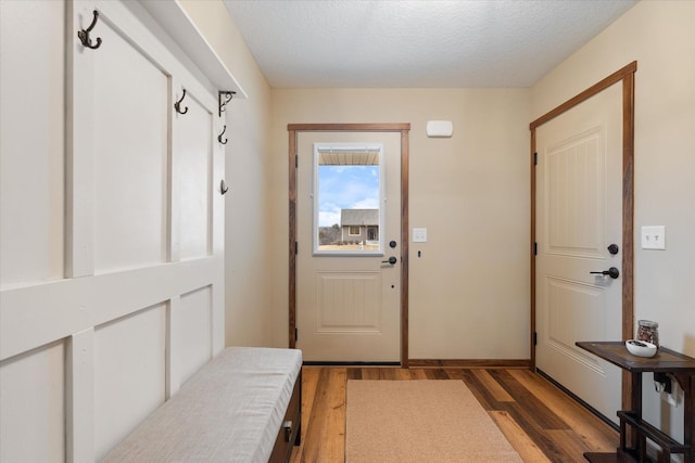 doorway featuring light wood finished floors and a textured ceiling