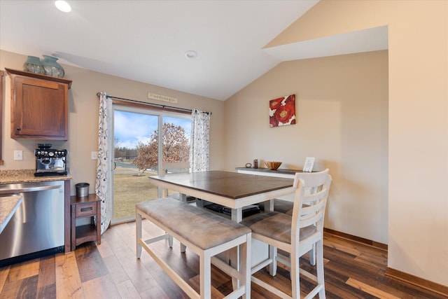 dining area with light wood-type flooring, baseboards, and vaulted ceiling