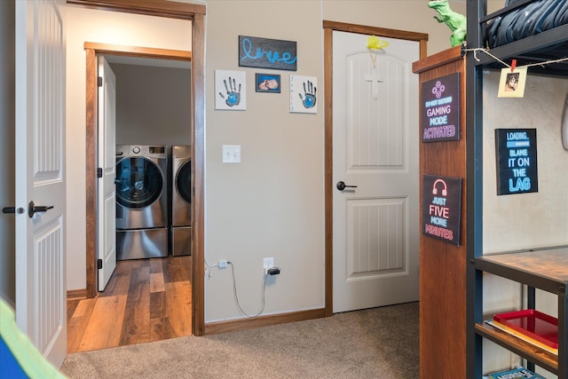 interior space with washing machine and dryer, baseboards, and wood finished floors