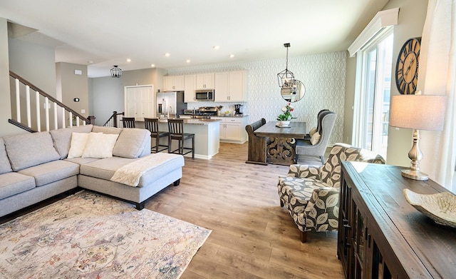 living room featuring stairway, recessed lighting, light wood-style flooring, and wallpapered walls