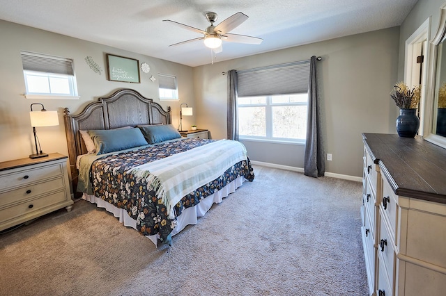 bedroom featuring light colored carpet, ceiling fan, and baseboards