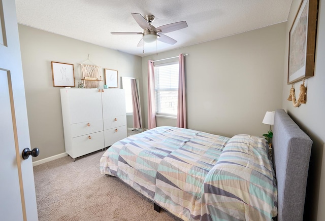 bedroom featuring light colored carpet, ceiling fan, a textured ceiling, and baseboards