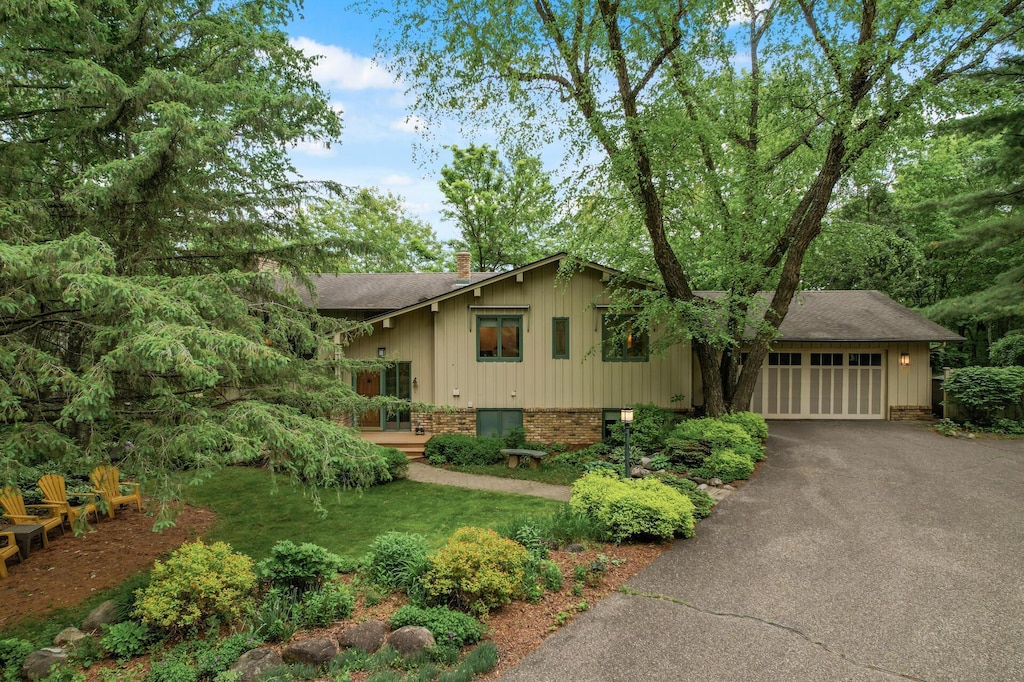 23577 Quentin Ave N, Scandia, MN 55073 - view of front of property with a chimney, driveway, a shingled roof, a garage, and brick siding
