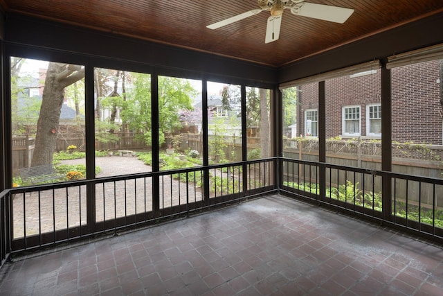 unfurnished sunroom featuring a ceiling fan and wooden ceiling