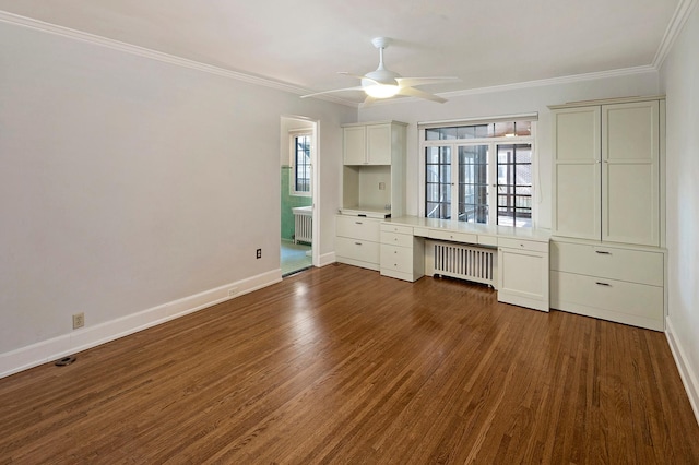 unfurnished bedroom featuring dark wood-style floors, radiator, built in study area, and crown molding