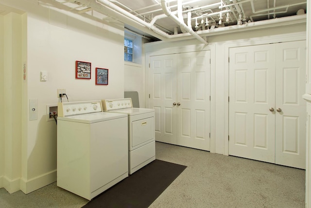 clothes washing area featuring washer and dryer, laundry area, and baseboards