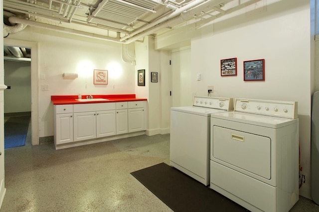 laundry room featuring cabinet space, washing machine and dryer, and a sink