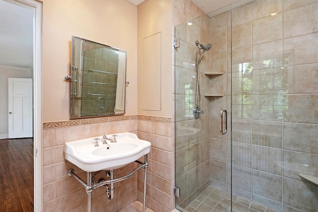 1769 Dupont Ave S Unit 1, Minneapolis, MN 55403 - full bathroom featuring a shower stall, crown molding, wood finished floors, tile walls, and wainscoting