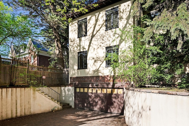 1769 Dupont Ave S Unit 1, Minneapolis, MN 55403 - view of home's exterior with brick siding, stairs, stucco siding, and a garage