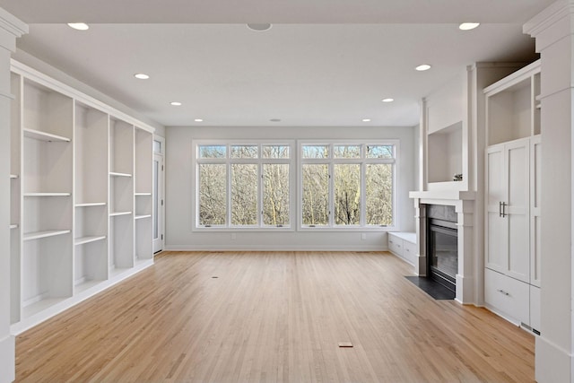 unfurnished living room featuring light wood-style floors, a fireplace with flush hearth, baseboards, and recessed lighting