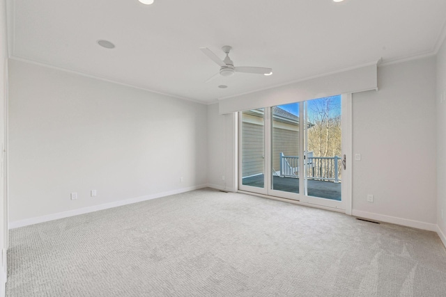 unfurnished room featuring carpet floors, visible vents, a ceiling fan, baseboards, and ornamental molding